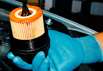 Mecánico sosteniendo un filtro de aceite limpio