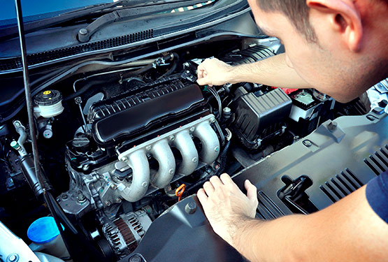 Persona revisando el motor de un automóvil azul